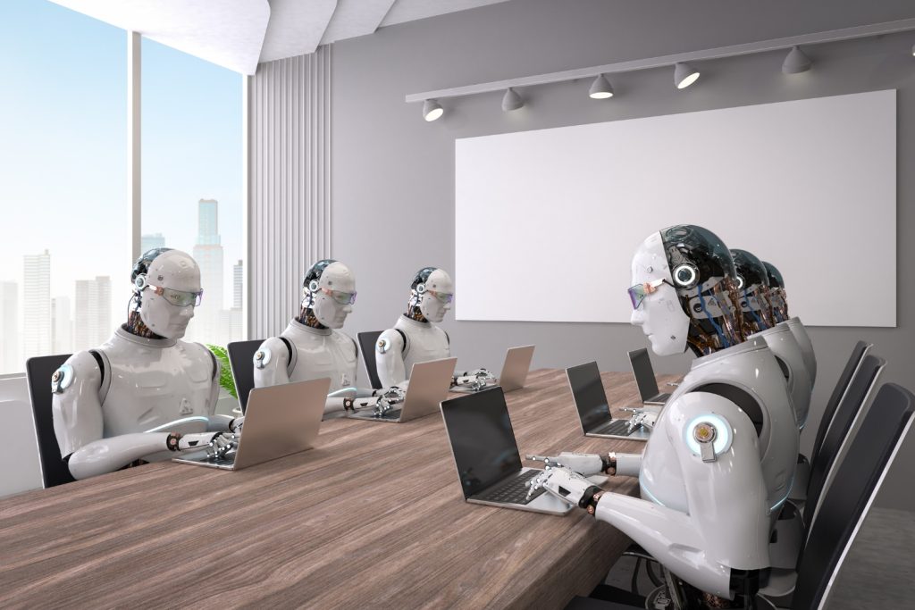Robots sit at a table and type on a computer.